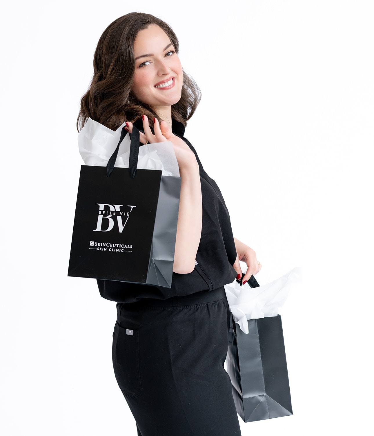 Woman smiling with shopping bags from SkinCeuticals