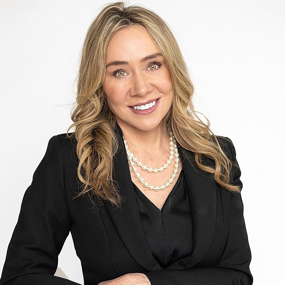Professional woman smiling in black blazer.