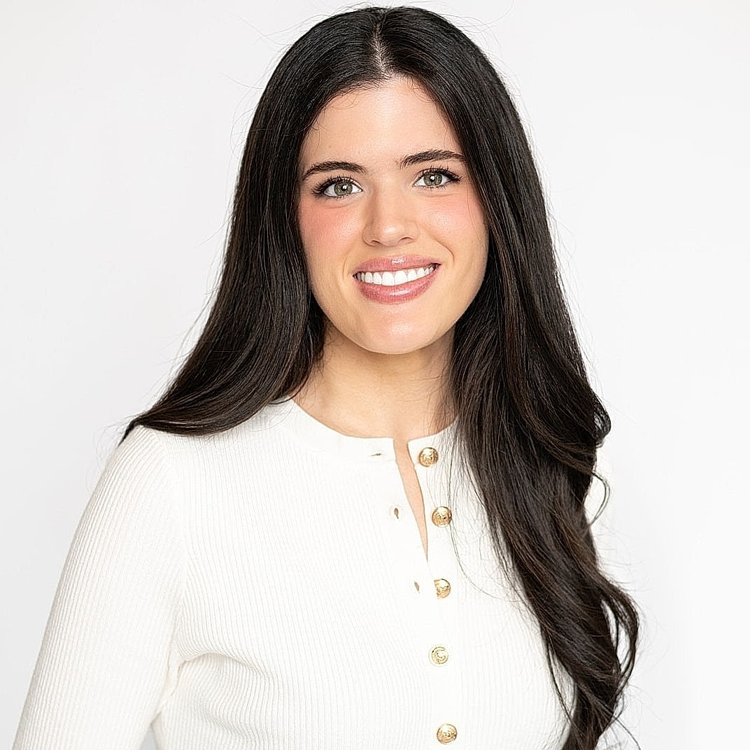 Smiling woman in a white cardigan.
