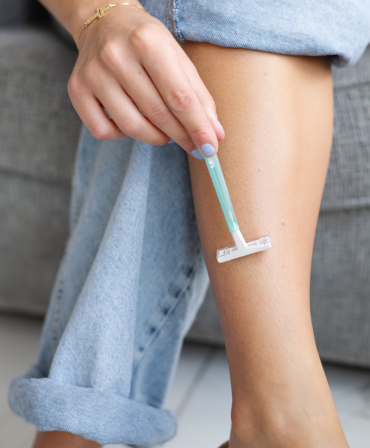 Woman shaving her leg with a razor.