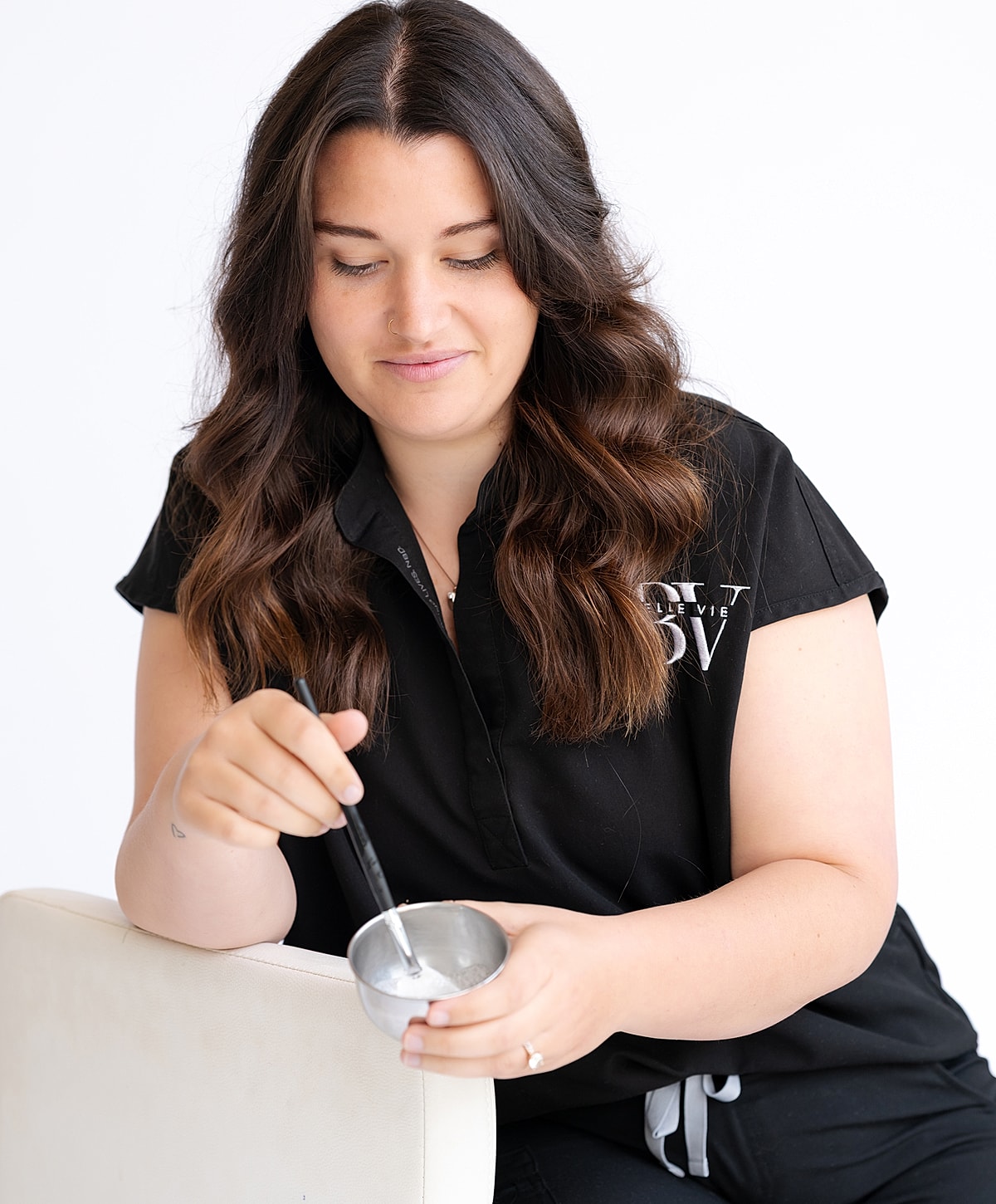 Person mixing product in a silver bowl.