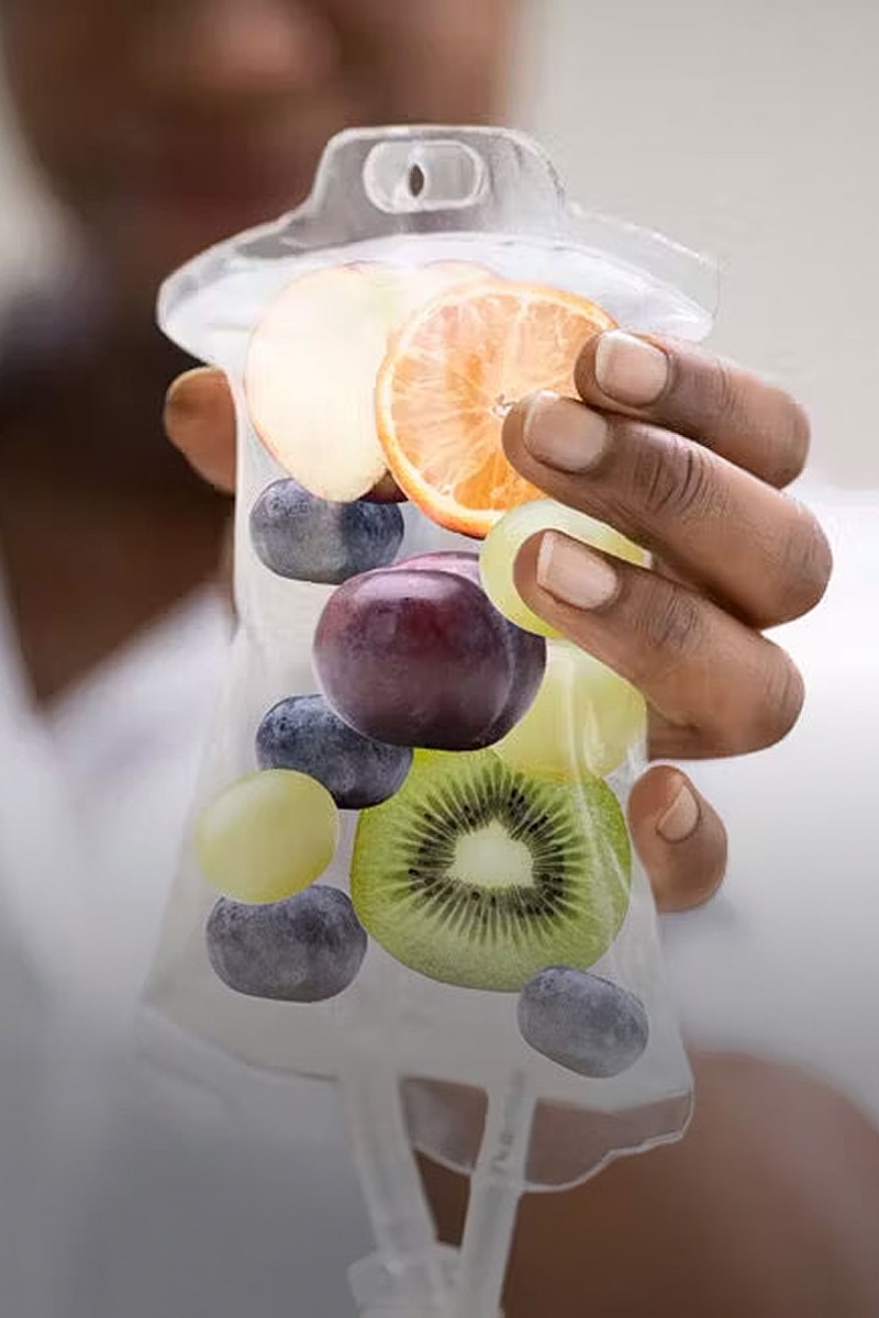 Fruit-filled IV bag held by a person.