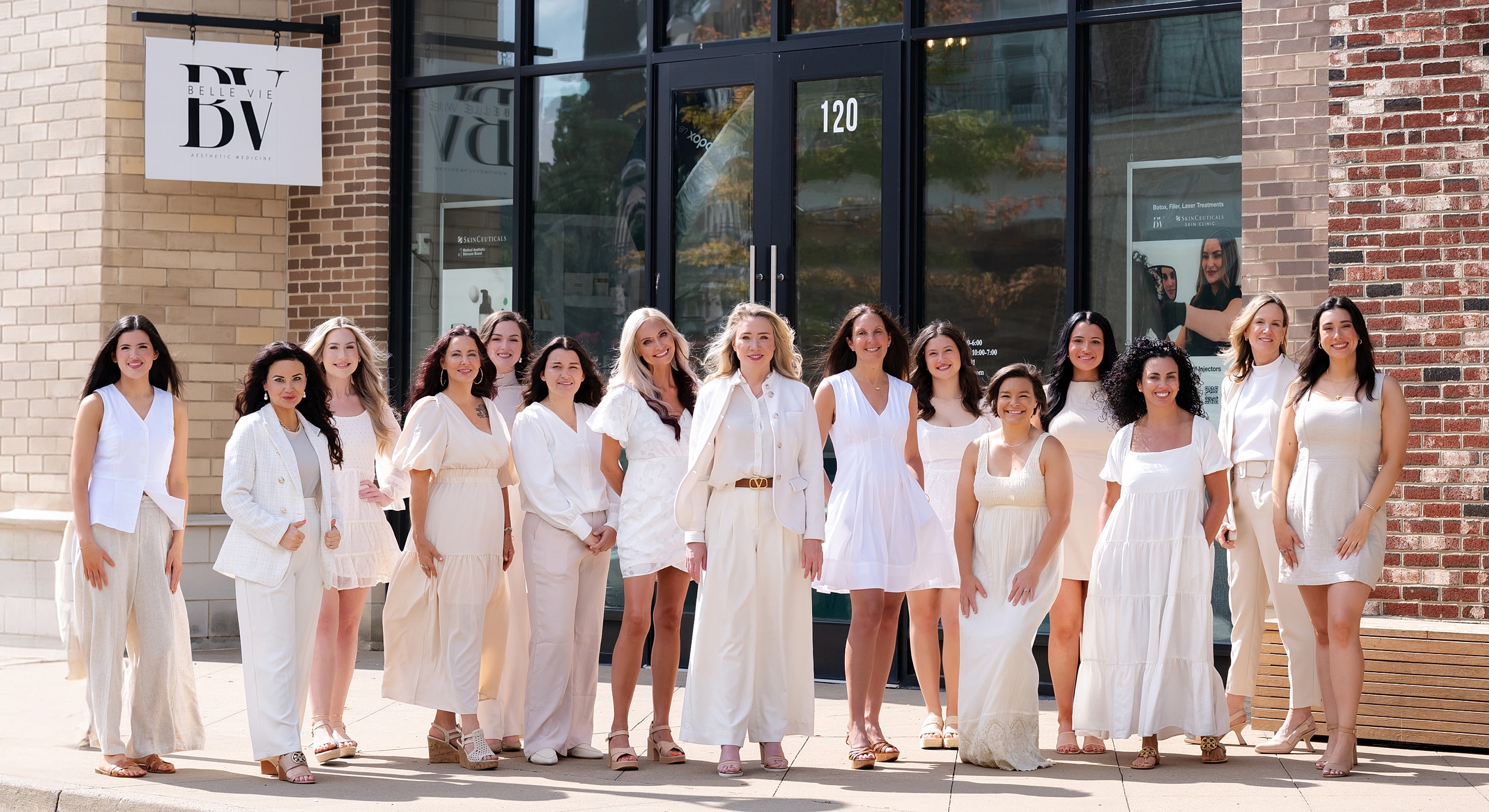 Group of women in white outfits outside.