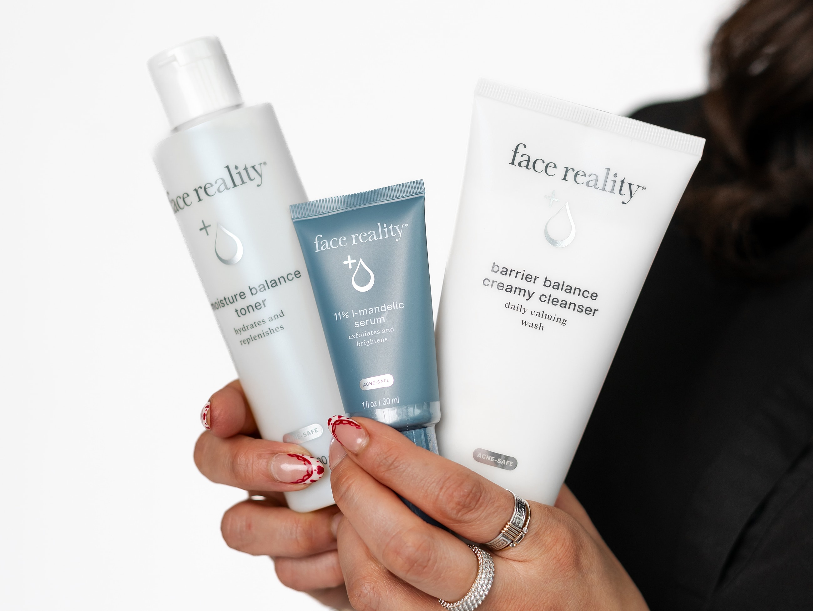 Face Reality skincare products held by a person.