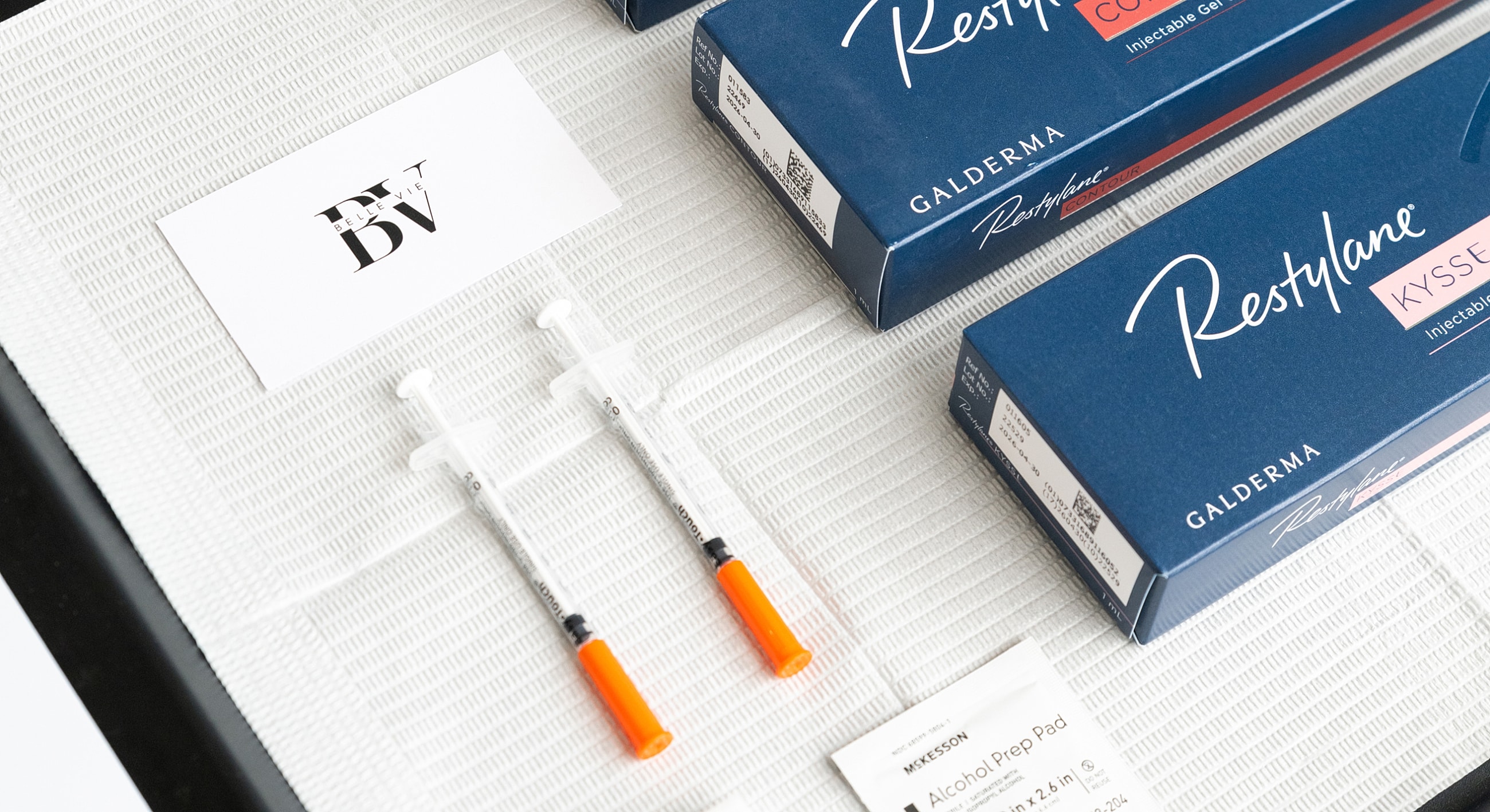 Restylane injectables and alcohol prep pads on table.