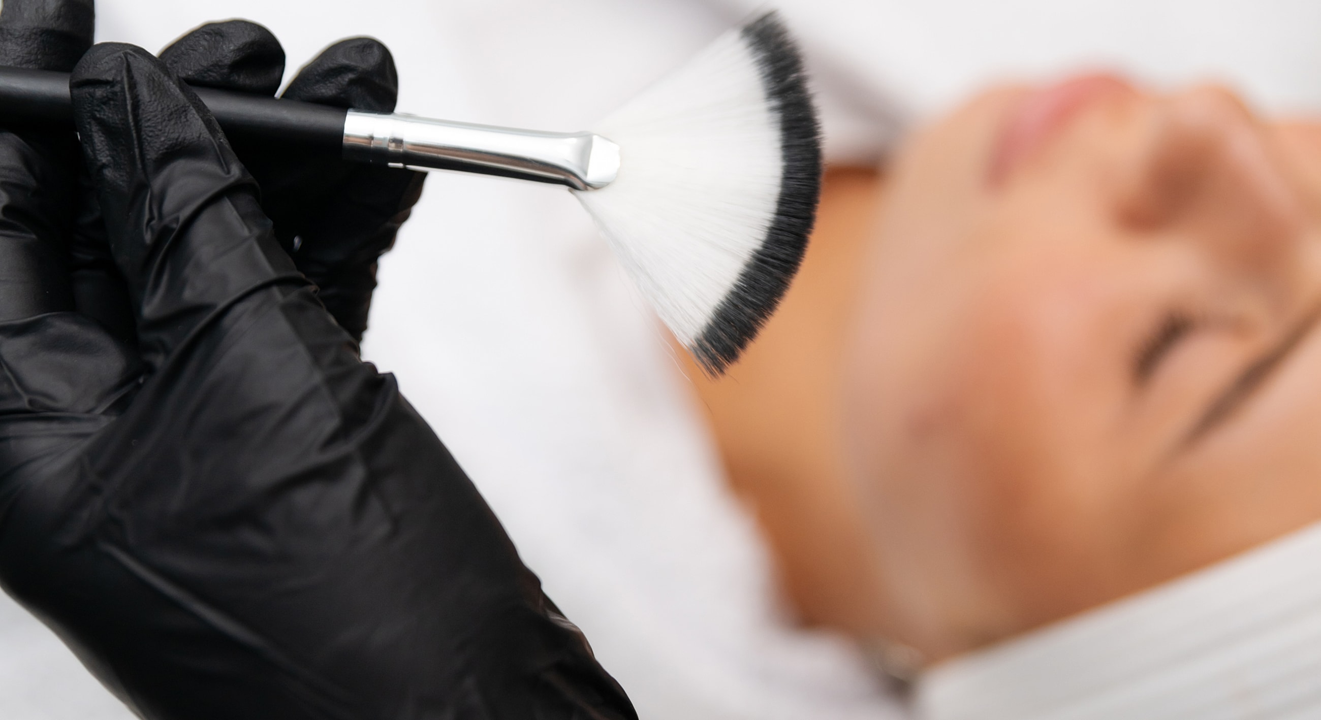 Applying facial treatment with a brush.